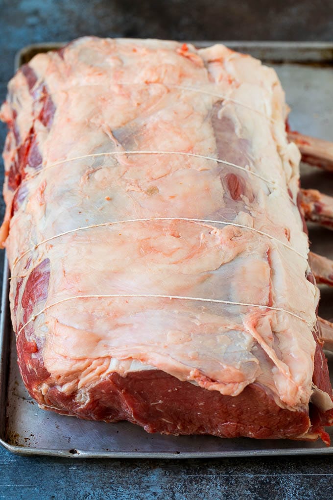 Prime Rib Recipe #primerib #beef #roast #dinner #thanksgiving #christmas #keto #lowcarb #fuyos A tied standing rib roast on a sheet pan.