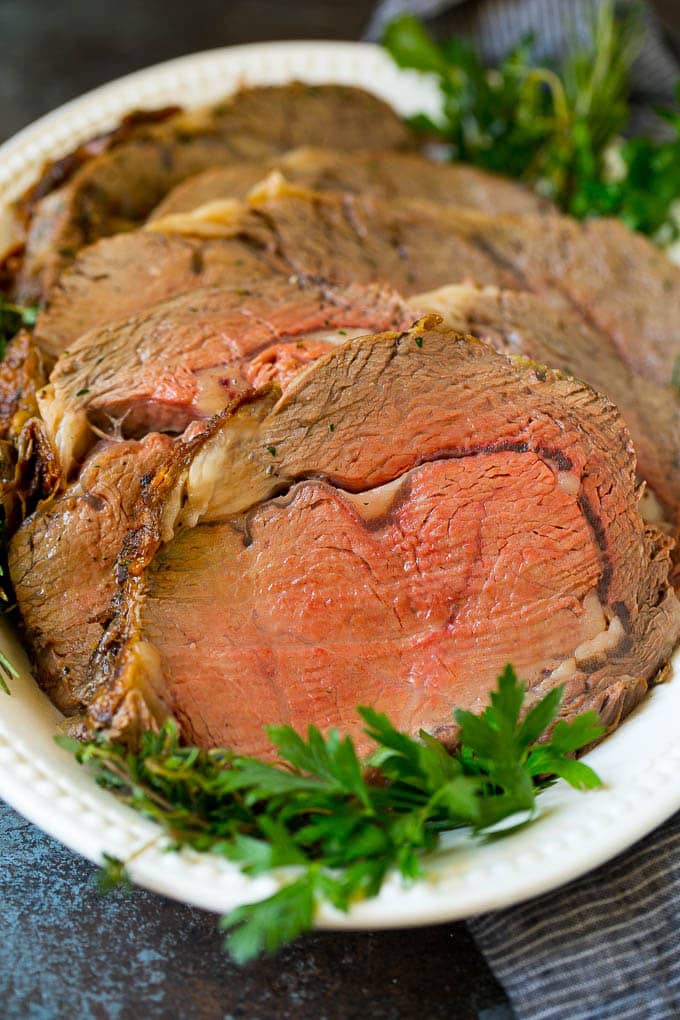 Prime Rib Recipe #primerib #beef #roast #dinner #thanksgiving #christmas #keto #lowcarb #fuyos Sliced slow roasted prime beef on a serving platter.
