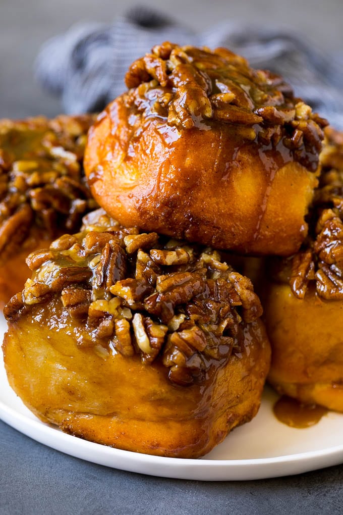 Sticky Buns Recipe | Sweet Rolls | Cinnamon Rolls #breakfast #brunch #cinnamon #pecans #fuyos #bread A plate of sticky buns topped with chopped nuts.