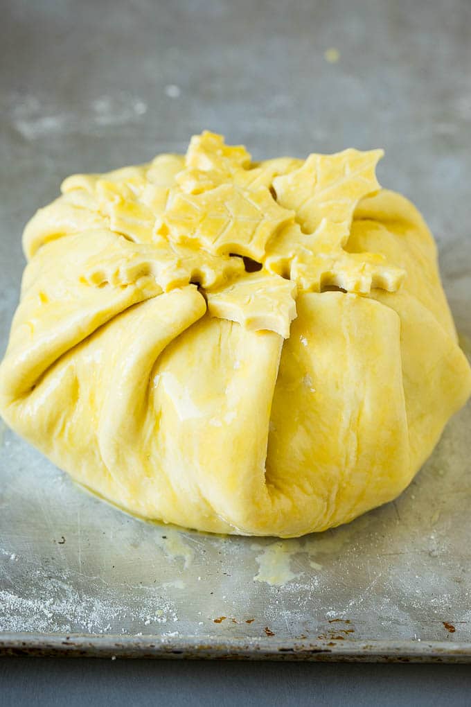 Baked Brie Recipe | Pastry Wrapped Brie #brie #cheese #appetizer #pecans #raspberries #fuyos Cheese wrapped in puff pastry and topped with egg wash.