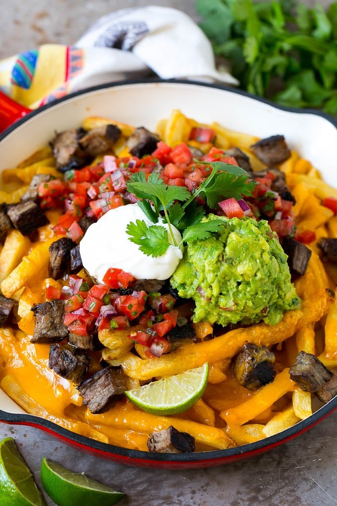 Carne Asada Fries Recipe | Steak Fries #fries #frenchfries #steak #salsa #avocado #cheese #dinner #appetizer #fuyos Carne asada fries topped with melted cheese, steak, salsa and guacamole.