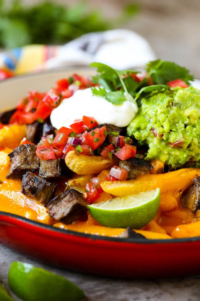 Carne Asada Fries Recipe | Steak Fries #fries #frenchfries #steak #salsa #avocado #cheese #dinner #appetizer #fuyos Carne asada fries in a skillet topped with sour cream, pico de gallo and steak.