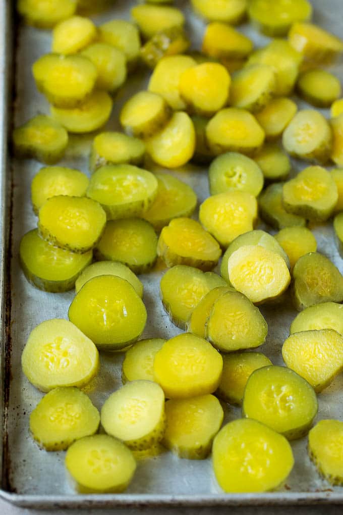 Fried Pickles Recipe #pickles #appetizer #snack #fuyos Sliced dills on a sheet pan.