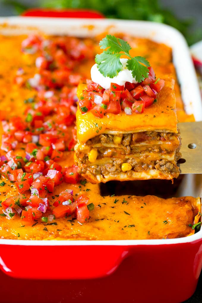 Mexican Lasagna Recipe | Mexican Casserole #mexican #lasagna #groundbeef #beans #dinner #cheese #fuyos A spatula serving up a portion of Mexican lasagna.