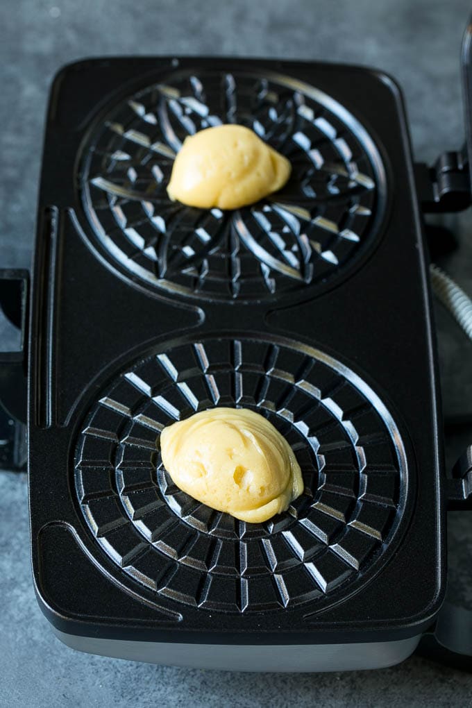 Pizzelle Cookies Recipe #cookies #baking #dessert #christmas #fuyos Dollops of dough in a cookie iron.