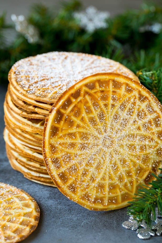 Pizzelle Cookies Recipe #cookies #baking #dessert #christmas #fuyos A stack of pizzelle cookies dusted with powdered sugar.