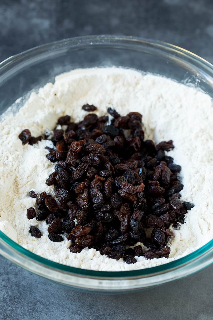 Irish Soda Bread Recipe #bread #baking #stpatricksday #sidedish #fuyos Flour, sugar, butter, baking powder and raisins in a mixing bowl.
