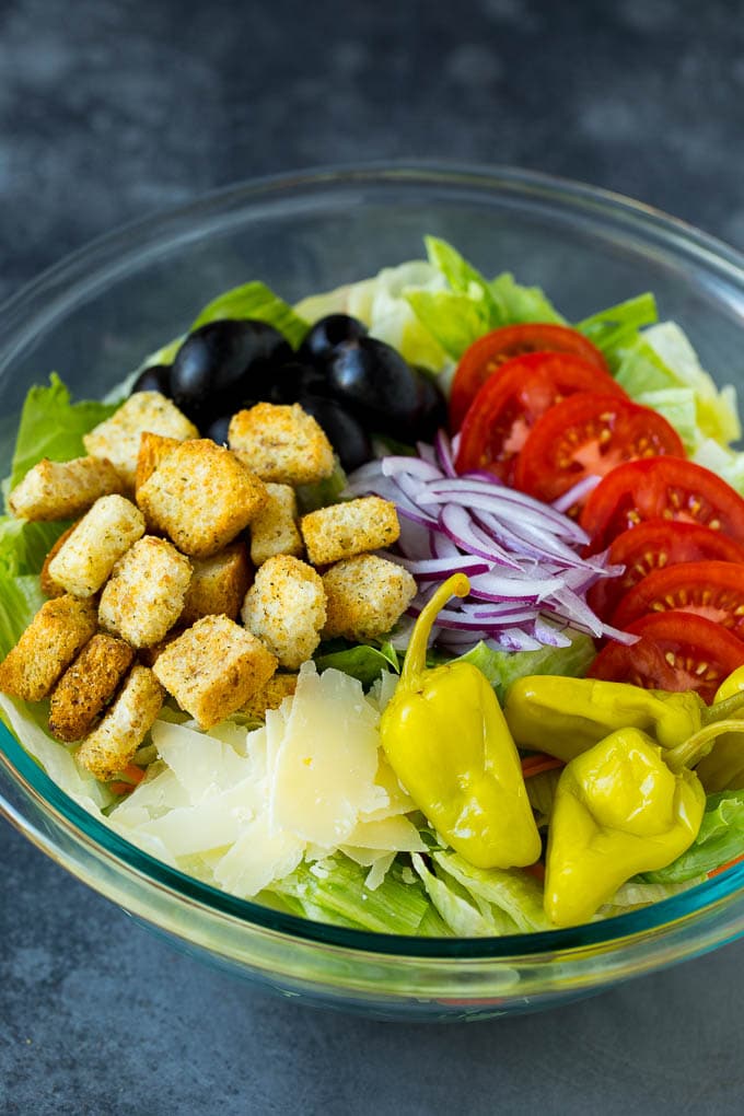 Olive Garden Salad Recipe | Italian Salad #salad #lettuce #olives #sidedish #dinner #fuyos Lettuce, vegetables, olives and croutons in a bowl.