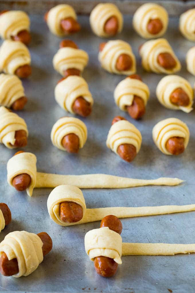 Hot dogs being rolled up in dough.