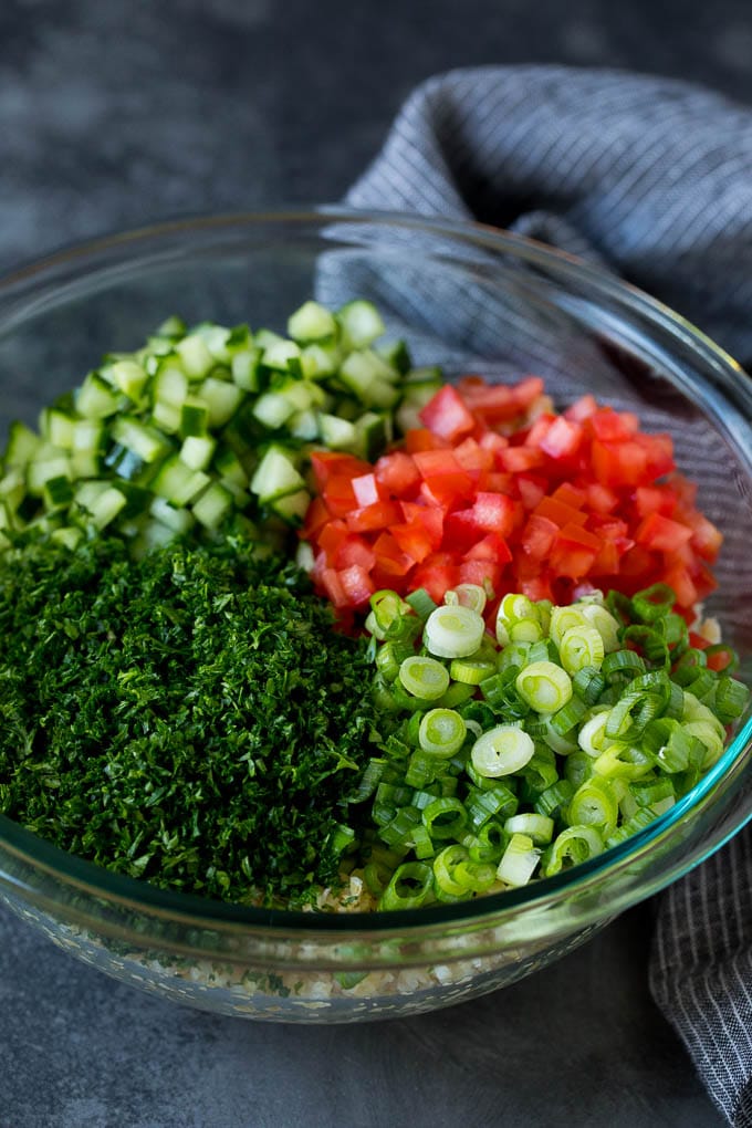 Tabbouleh Salad | Tabouli #salad #wheat #tomatoes #cucumber #healthy #sidedish #dinner #fuyos A bowl of bulgur topped with herbs, tomatoes and cucumber.