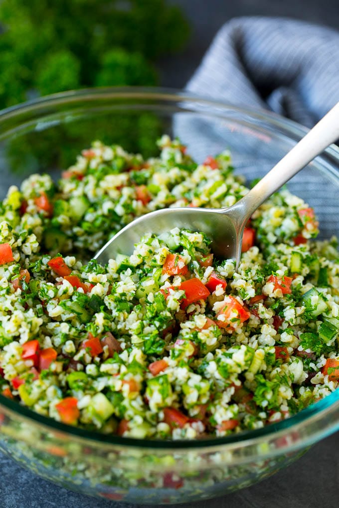 Tabbouleh Salad | Tabouli #salad #wheat #tomatoes #cucumber #healthy #sidedish #dinner #fuyos A bowl of tabbouleh with a serving spoon in it.