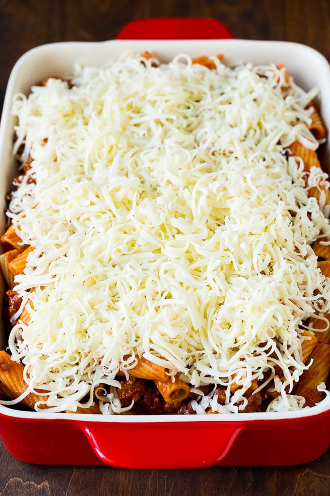 Baked Rigatoni Pasta #pasta #dinner #italianfood #groundbeef #fuyos #casserole A pan of pasta in sauce topped with shredded cheese.