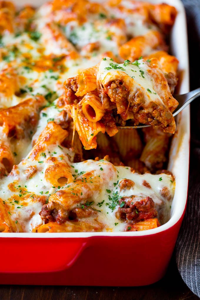 Baked Rigatoni Pasta #pasta #dinner #italianfood #groundbeef #fuyos #casserole A spoon serving up a portion of baked rigatoni pasta.