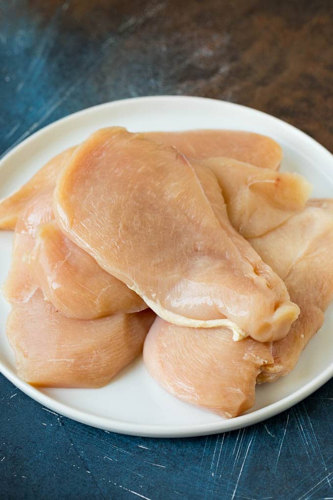 Chicken Francese Recipe #chicken #lemon #dinner #fuyos Thin cut chicken breasts on a plate.