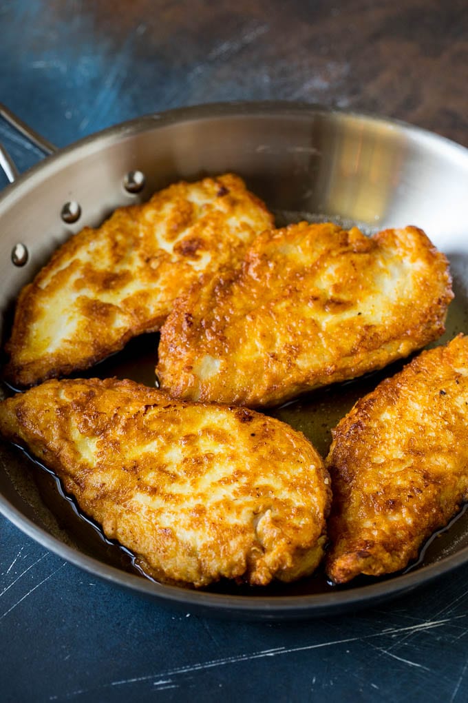 Chicken Francese Recipe #chicken #lemon #dinner #fuyos Battered and pan fried chicken cutlets in a pan.