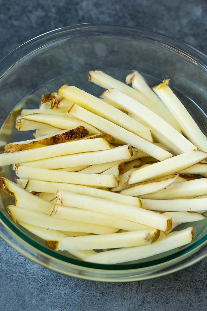 Homemade French Fries Recipe #potatoes #fries #dinner #fuyos Sliced potato sticks in a bowl of water.