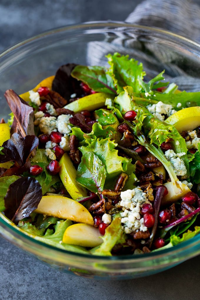 Pear Salad Recipe #salad #pears #fall #winter #dinner #fuyos A bowl of pear salad with pomegranate, blue cheese and candied pecans.
