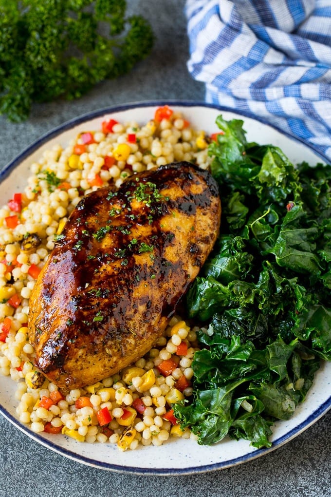 Grilled chicken served with a side of sauteed kale.