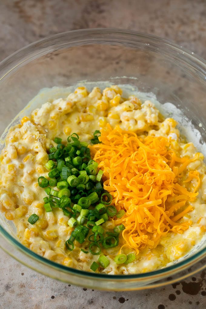 These crispy corn fritters are easy to make and are the perfect appetizer or lighter main course. #corn #fuyos Corn batter topped with green onions and shredded cheese.