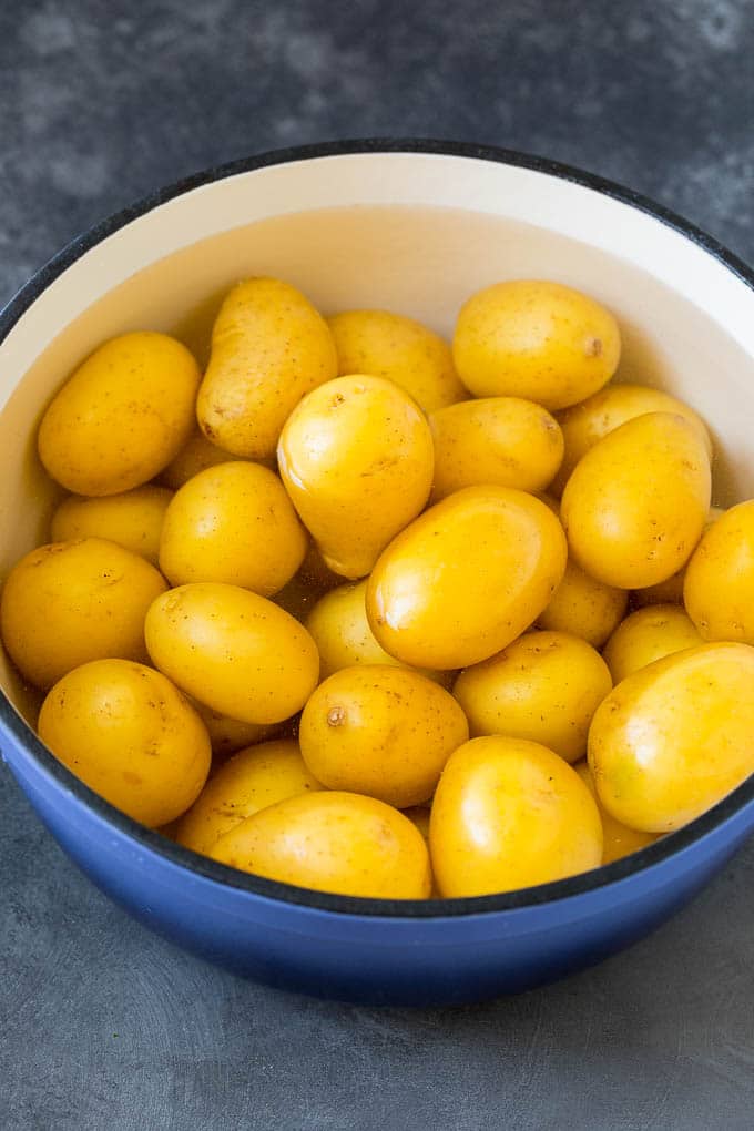 Baby potatoes in a pot of water.