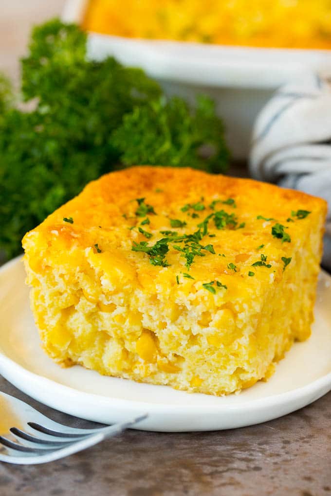 A square of cornbread casserole topped with parsley.