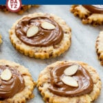 An image of almond roca cookies loaded with toffee and almonds and topped with creamy milk chocolate. on a marble slab.