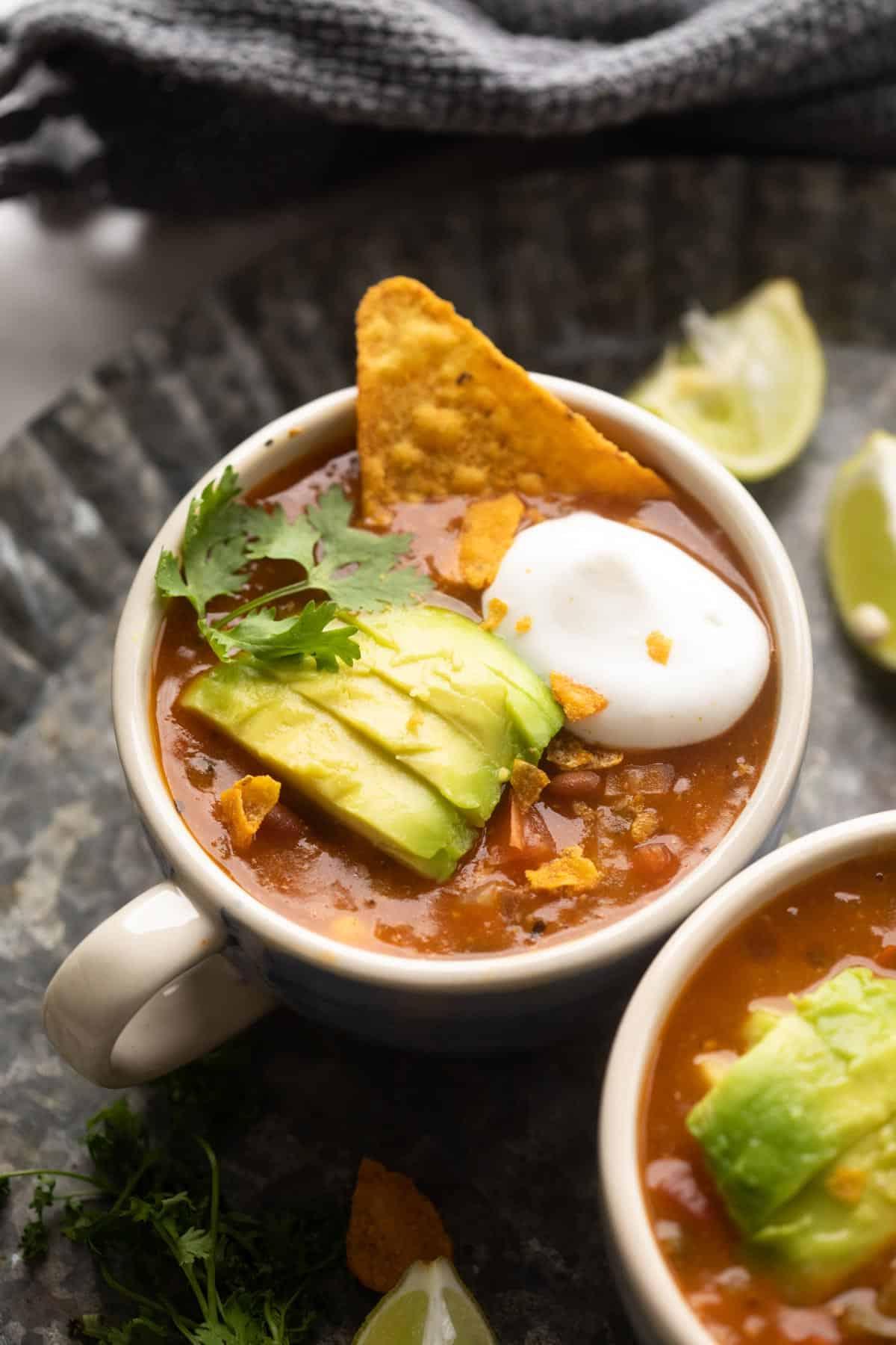 Zuppa Messicana Vegetariana con Fagioli 2 Ciotola di zuppa messicana vegetariana guarnita con avocado, coriandolo, panna acida e tortilla chips