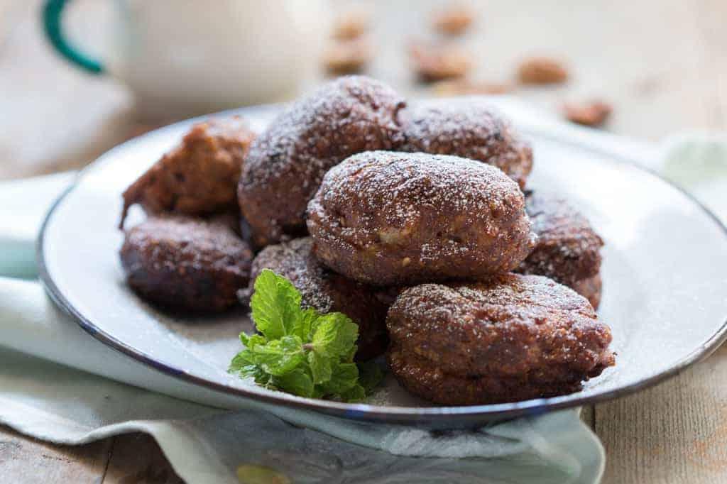 Frittelle di Banana Indiane Speziate con Menta le frittelle servite su un piatto bianco, guarnite con foglie di menta