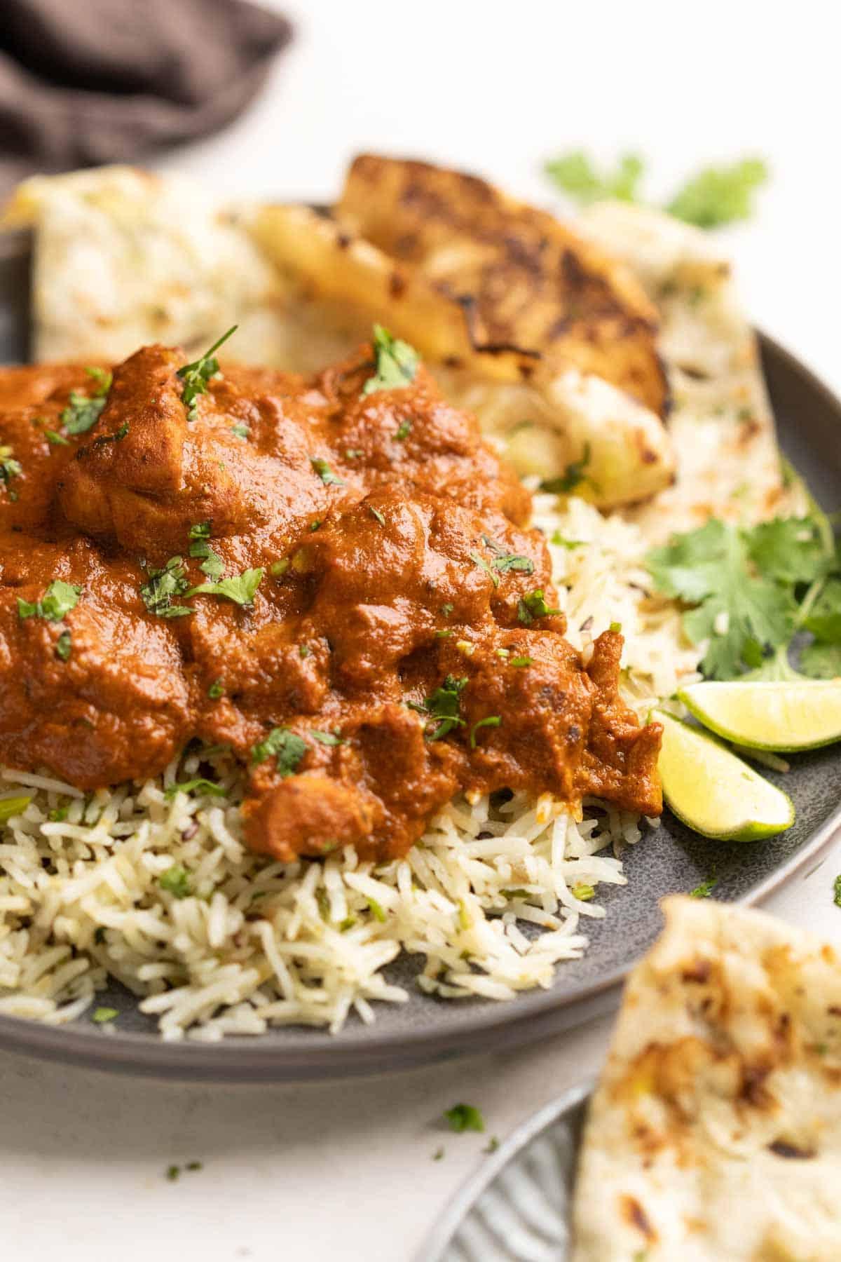 Instant Pot Pollo Tikka Masala 2 Un piatto di riso jeera guarnito con pollo tikka masala e un contorno di naan