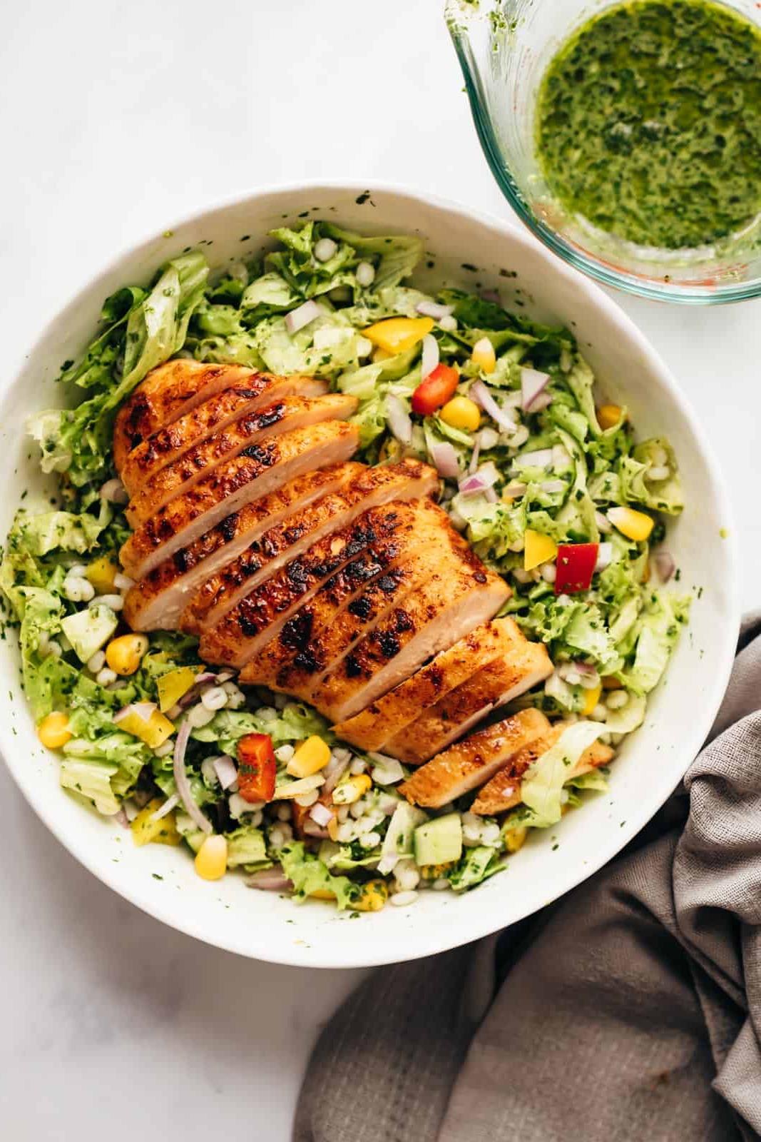 Insalata di orzo e pollo servita in una ciotola grigia pronta da gustare