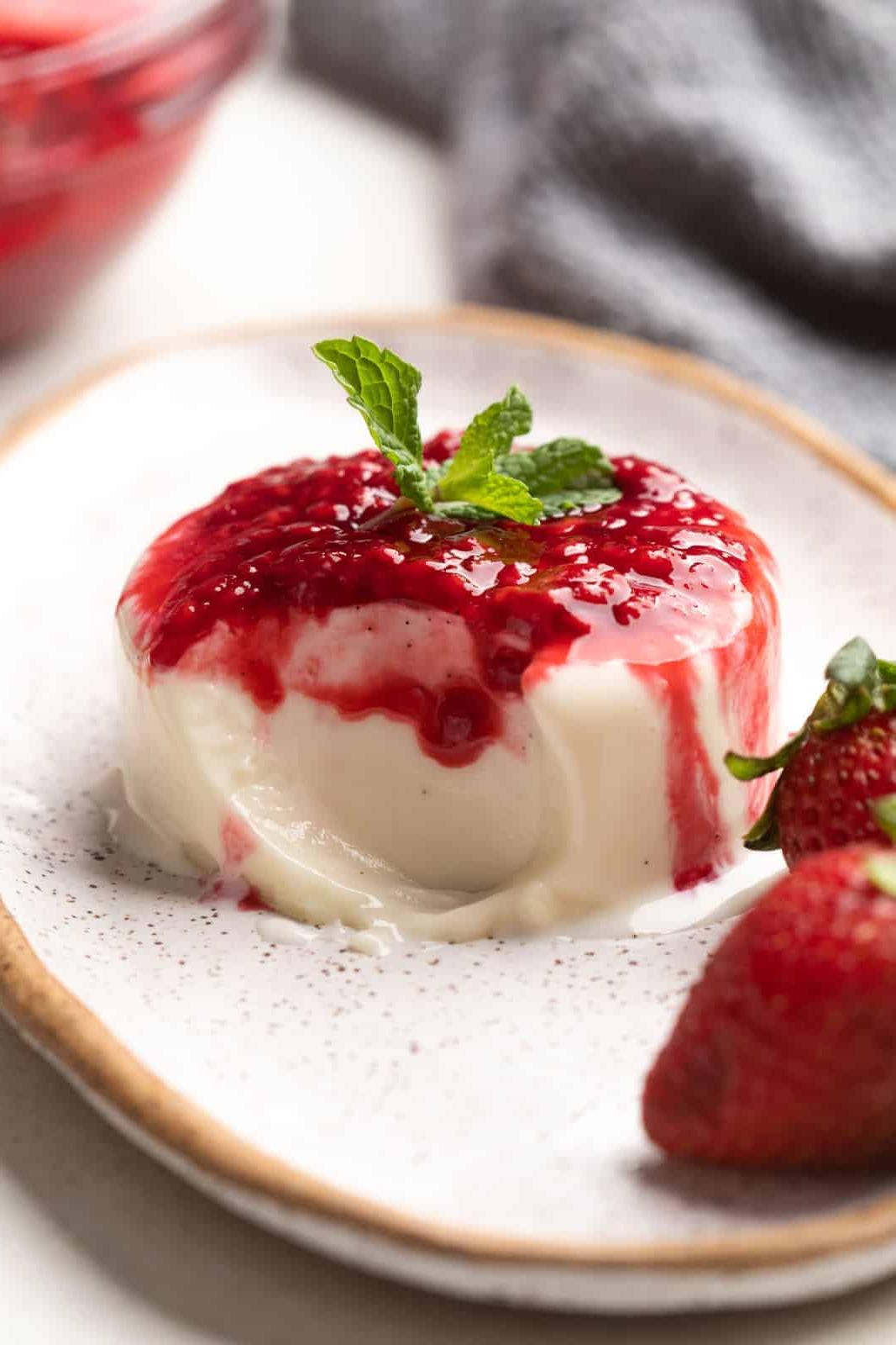Come fare la Panna Cotta – Vaniglia Classica! 2 Panna cotta alla vaniglia su un piatto con un morso