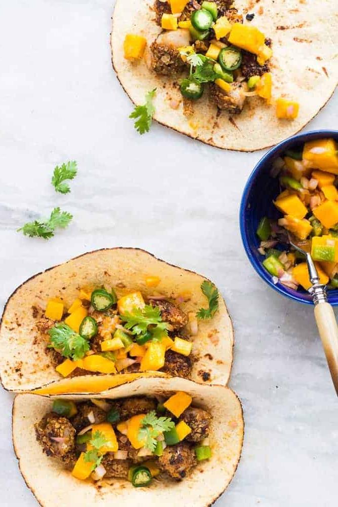 Tacos di Pesce Croccante con Avena + Salsa di Mango Ricetta facile e salutare per tacos di pesce croccante all'avena, pronta in soli 15 minuti. Usa merluzzo, tilapia, dentice o qualsiasi altro pesce bianco. Invece della solita insalata di cavolo, guarnisci con salsa di mango e coriandolo per un tocco in più! Perfetta per la tua prossima cena o barbecue estivo!