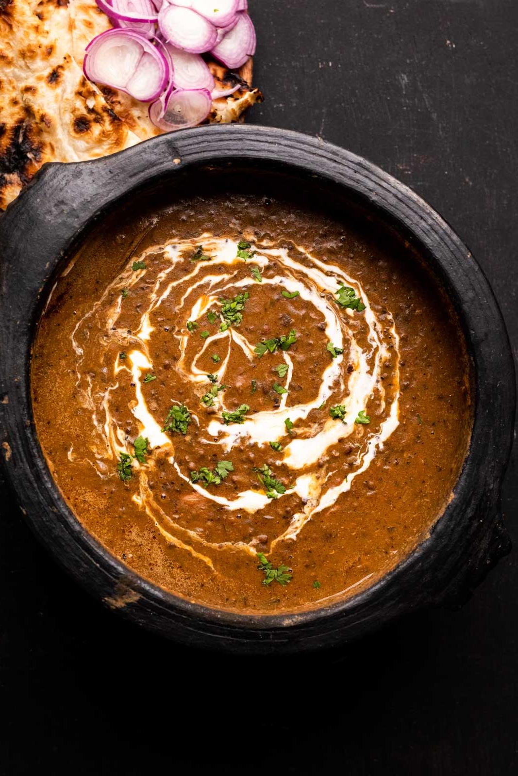 Dal Makhani – La Ricetta Definitiva per Fornello e Pentola a Pressione 2 Dal Makhani indiano servito in una pentola di terracotta, con panna versata sopra