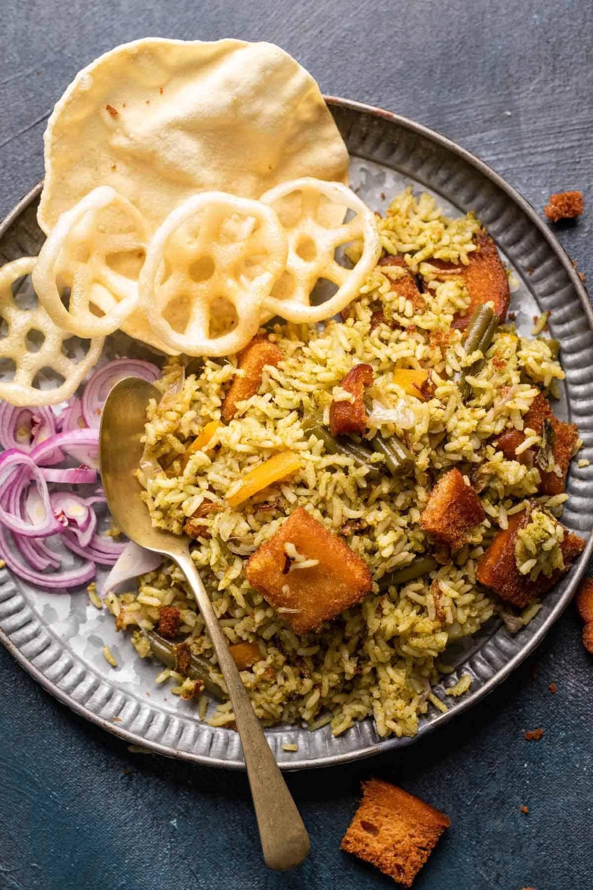 Riso Bath di Kavitha Aunty 2 Rice bath served in a grey plate with fryums, poppdum and onions on the side