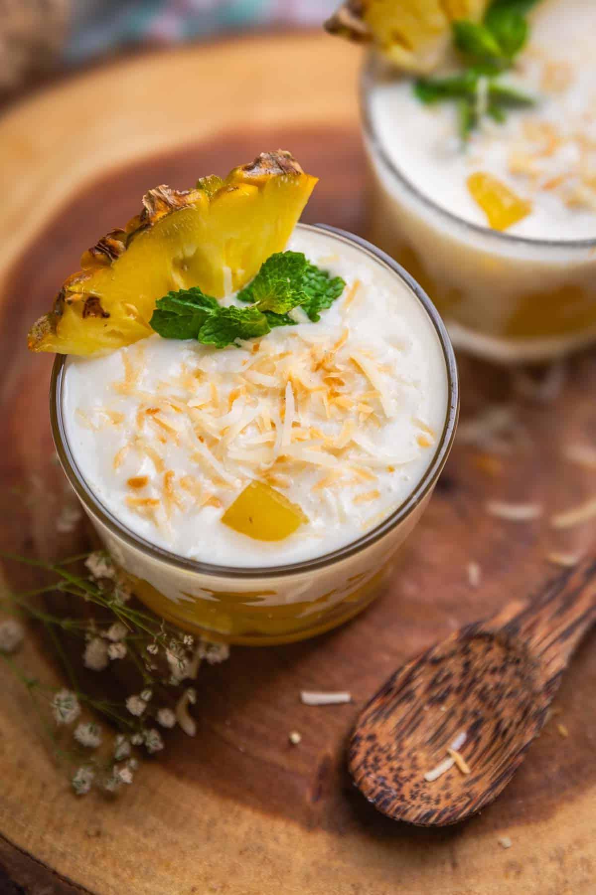 Budino di Cocco con Gelea all'Ananas 2 coconut pudding with pineapple jelly garnished with toasted coconut flakes, pineapple slice and mint leaves and served in shot glasses