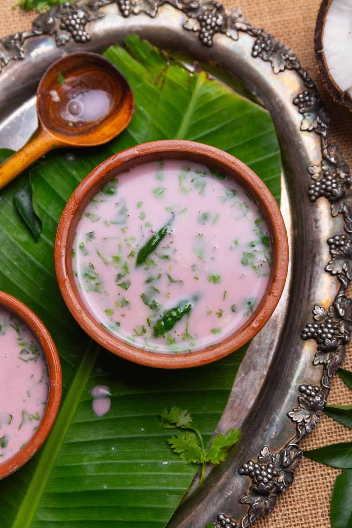 Sol Kadhi | Curry di Kokum 3 Sol Kadhi servito in piccole ciotole di terracotta con un cucchiaio, pronto per il consumo