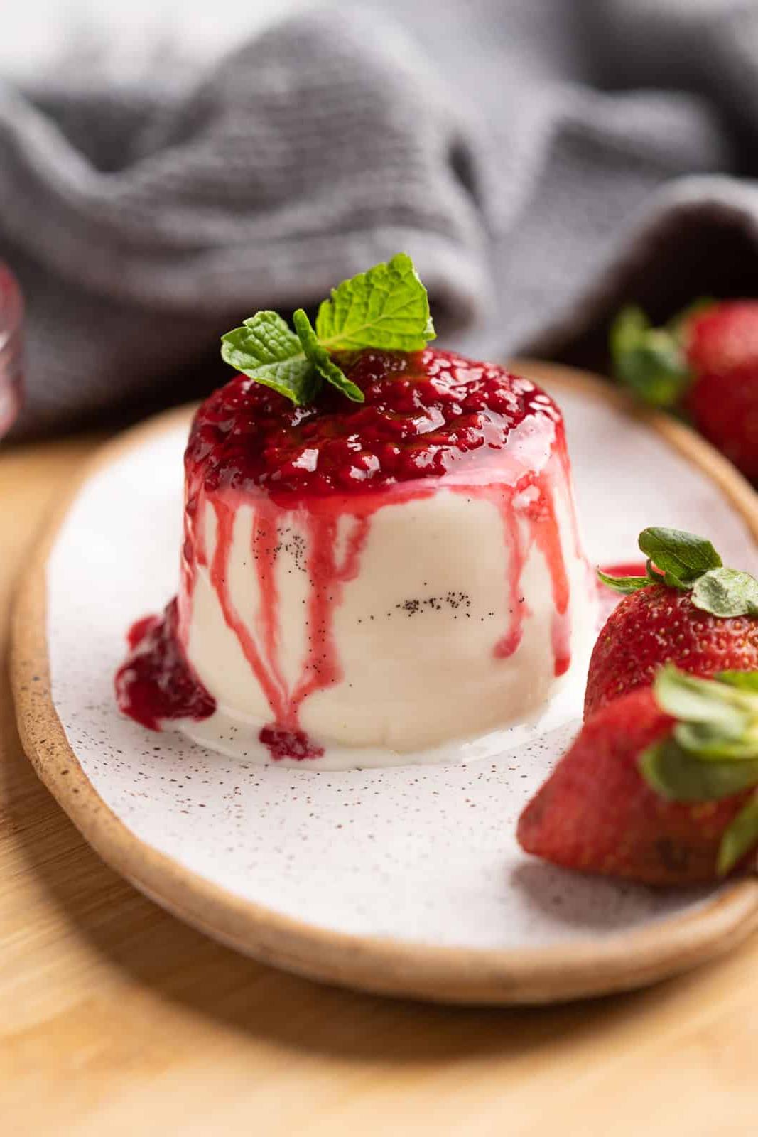 Come fare la Panna Cotta – Vaniglia Classica! 3 Panna cotta classica con puntini di vaniglia, guarnita con coulis di lamponi, servita su un piatto bianco
