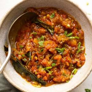 Chutney di Pomodoro – 2 Modi 4 Chutney di pomodoro in stile Nord Indiano servito in una ciotola di ceramica con un cucchiaio a lato