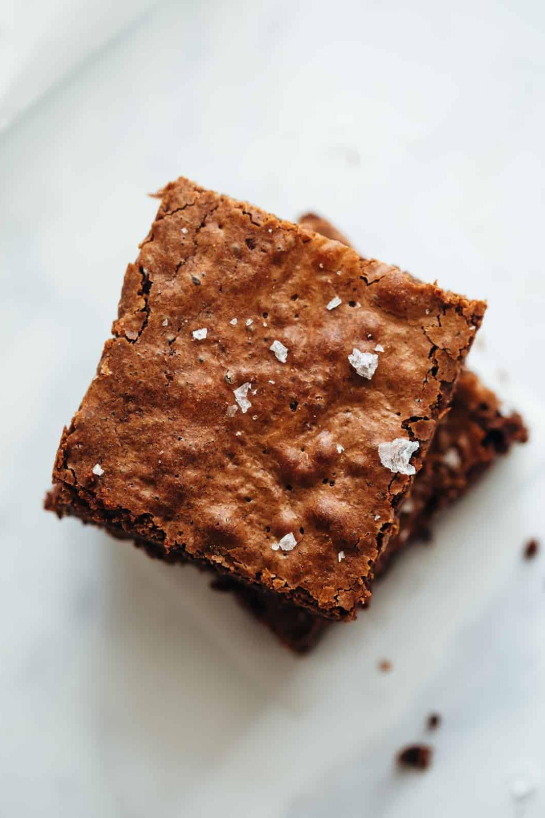 Brownies di Farina di Ceci (Facili, Senza Glutine, Scioglievoli) 4 Brownies di farina di ceci impilati uno sull'altro con sale marino