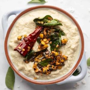Ricette di Chutney per Idli e Dosa 4 Chutney di Cocco servito in una ciotola azzurra con condimento sopra