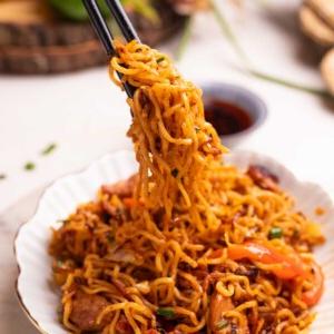 Noodles al Pollo Piccante | Noodles al Pollo con Olio di Peperoncino 5 un'immagine di noodles di pollo al peperoncino presi con un paio di bacchette