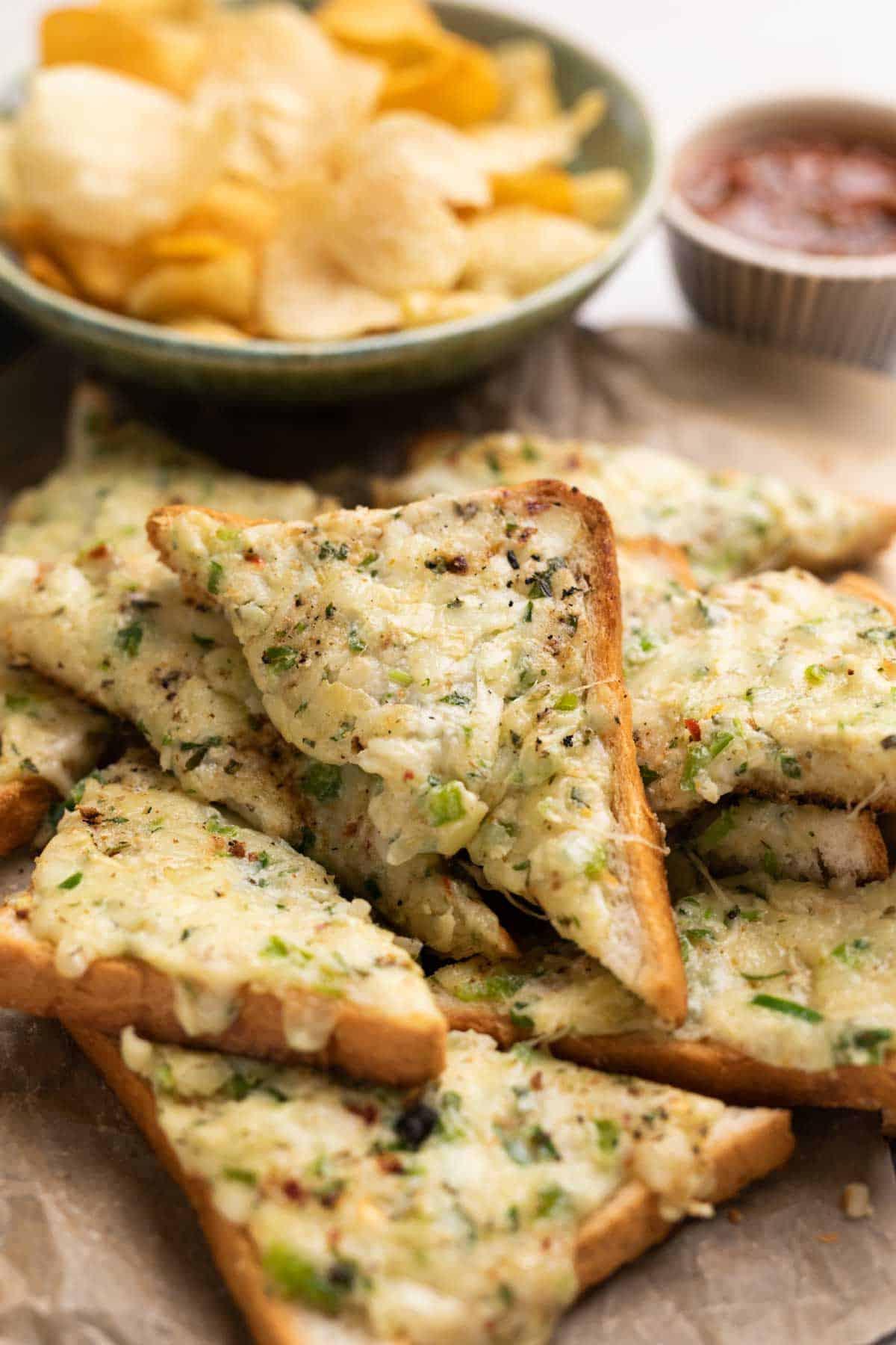 Pane all'aglio con formaggio e peperoncino 5 Tostini all'aglio con formaggio e peperoncino appena tolti dalla padella su un piatto di portata