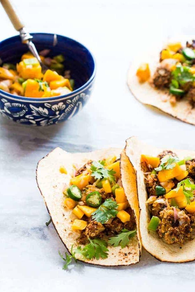 Tacos di Pesce Croccante con Avena + Salsa di Mango Questa ricetta per tacos di pesce croccante all'avena, super facile e salutare, richiede SOLO 15 minuti dall'inizio alla fine. Usa merluzzo, tilapia, dentice o qualsiasi altro pesce bianco. Invece della solita insalata di cavolo, ho guarnito questi tacos con salsa di mango e coriandolo per un tocco in più! Perfetti per la tua prossima cena o barbecue estivo!