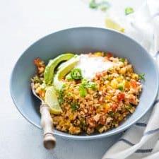 Riso di Cavolfiore Messicano a Basso Contenuto di Carboidrati (Paleo, Vegano, Keto) 4 Riso di Cavolfiore Messicano guarnito con panna acida e avocado.