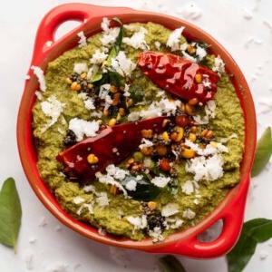 Ricette di Chutney per Idli e Dosa 6 Chutney di Cocco e Coriandolo servito in una ciotola rossa con condimento sopra