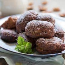 Frittelle di banana indiane speziate 2 Le frittelle servite su un piatto bianco e guarnite con foglie di menta.