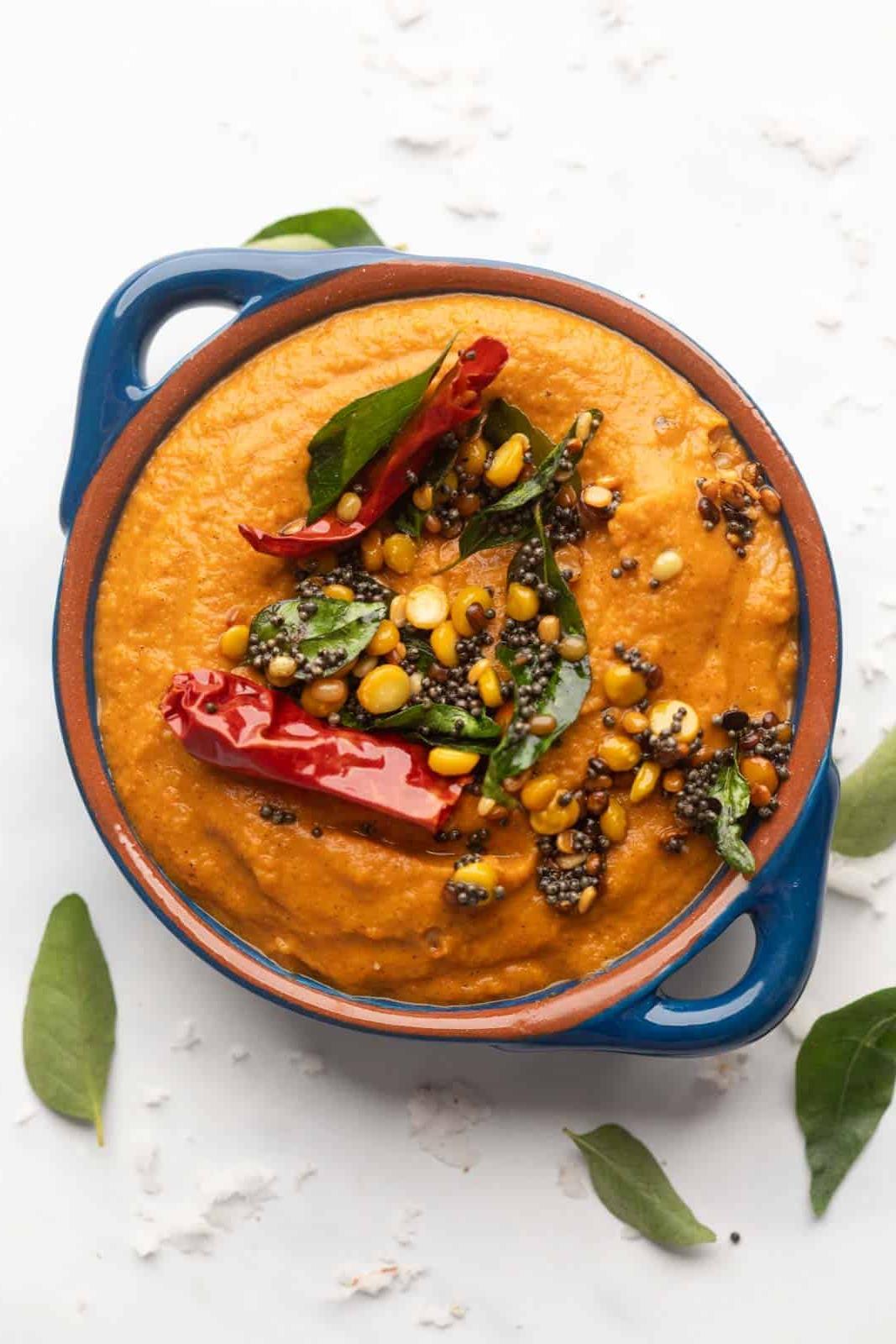 Ricette di Chutney per Idli e Dosa 7 Chutney di Pomodoro servito in una ciotola blu con condimento sopra