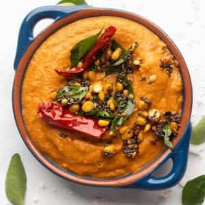 Ricette di Chutney per Idli e Dosa 8 Chutney di Pomodoro servito in una ciotola blu con condimento sopra