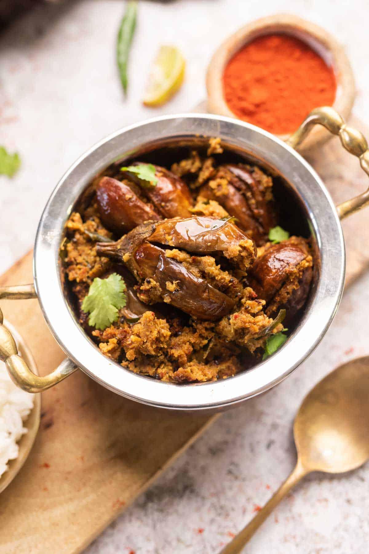 Melanzane Ripiene in Friggitrice ad Aria o al Forno 8 Un'immagine di melanzane ripiene cotte nella friggitrice ad aria guarnite con foglie di coriandolo e servite in una handi (pentola tradizionale indiana)