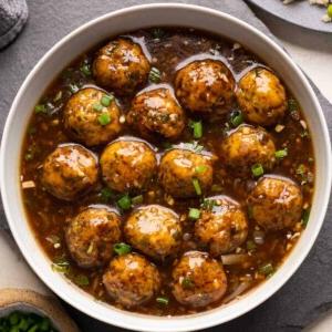 Manchurian Vegetariano | Come preparare il Manchurian 9 Manchurian Vegetariano servito in una ciotola bianca con riso fritto e cipollina verde a lato